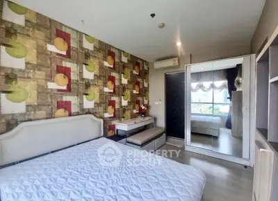 Stylish bedroom with modern decor and large mirror reflecting natural light