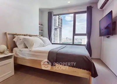 Modern bedroom with city view, featuring a cozy bed and wall-mounted TV, perfect for urban living.