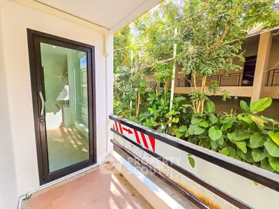 Charming balcony with lush garden view in modern apartment complex