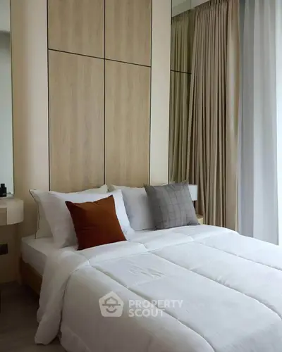 Modern bedroom with stylish decor and natural light, featuring cozy bedding and elegant curtains.