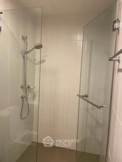 Modern bathroom with glass shower enclosure and sleek fixtures.