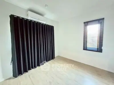Spacious empty room with modern window treatments and air conditioning