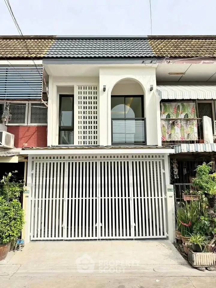 Charming townhouse with modern facade and gated entrance in a cozy neighborhood.