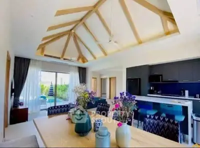 Spacious modern living room with vaulted ceiling and open kitchen layout, featuring stylish decor and natural light.