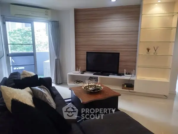 Modern living room with sleek TV setup and cozy seating area.