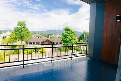 Spacious balcony with scenic view of lush greenery and residential area
