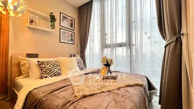 Luxurious bedroom with city view, elegant decor, and floor-to-ceiling windows for natural light.