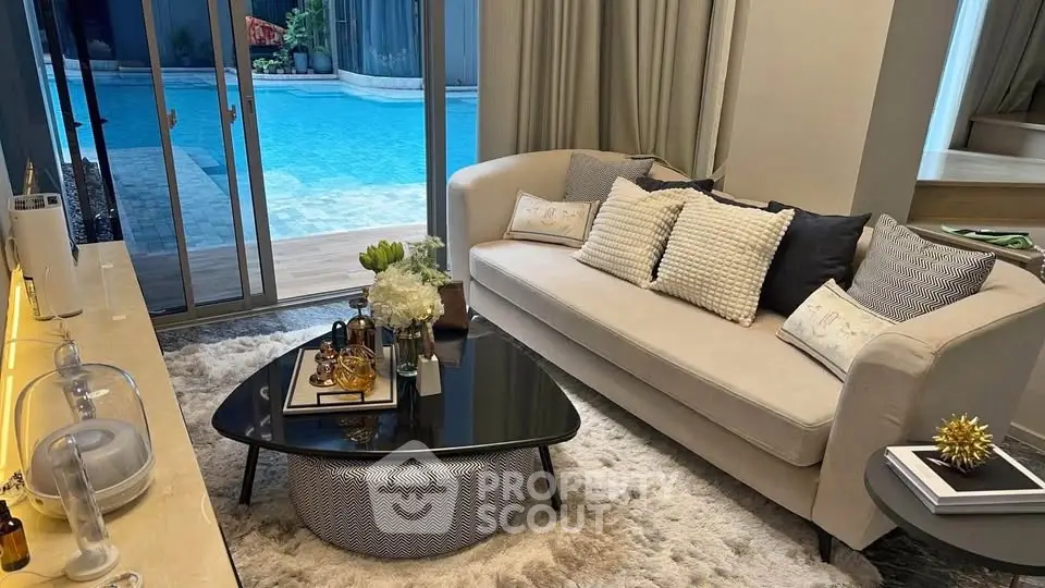 Luxurious living room with pool view, elegant sofa, and chic decor for ultimate relaxation.