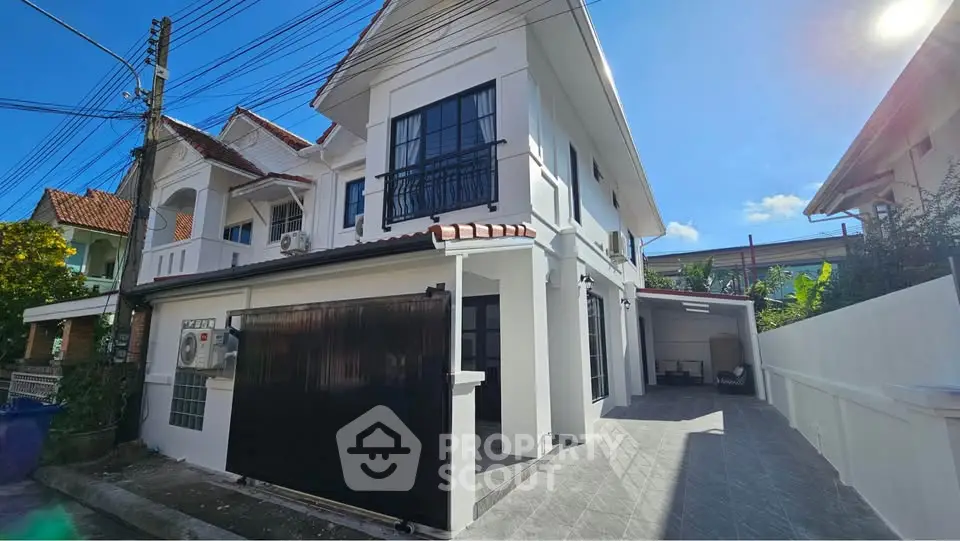 Charming two-story white house with driveway and modern exterior design in a sunny neighborhood.