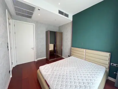 Modern bedroom with stylish green accent wall and sleek wardrobe