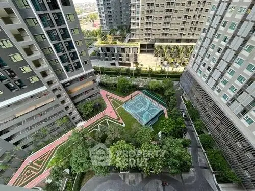 Stunning aerial view of modern apartment complex with lush garden and sports court, perfect for urban living.