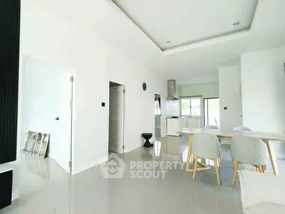 Modern open-plan dining area with sleek white interiors and stylish furniture.