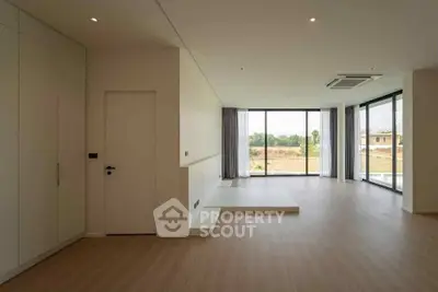 Spacious modern living room with large windows and wooden flooring