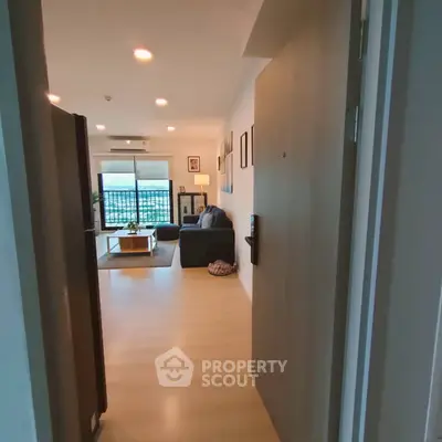 Modern living room with stylish decor and large window offering natural light and city view.