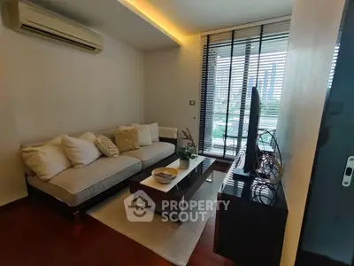 Cozy living room with modern decor and city view, featuring a comfortable sofa and stylish coffee table.
