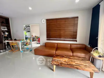 Spacious living room with modern leather sofa and wooden coffee table, perfect for family gatherings.