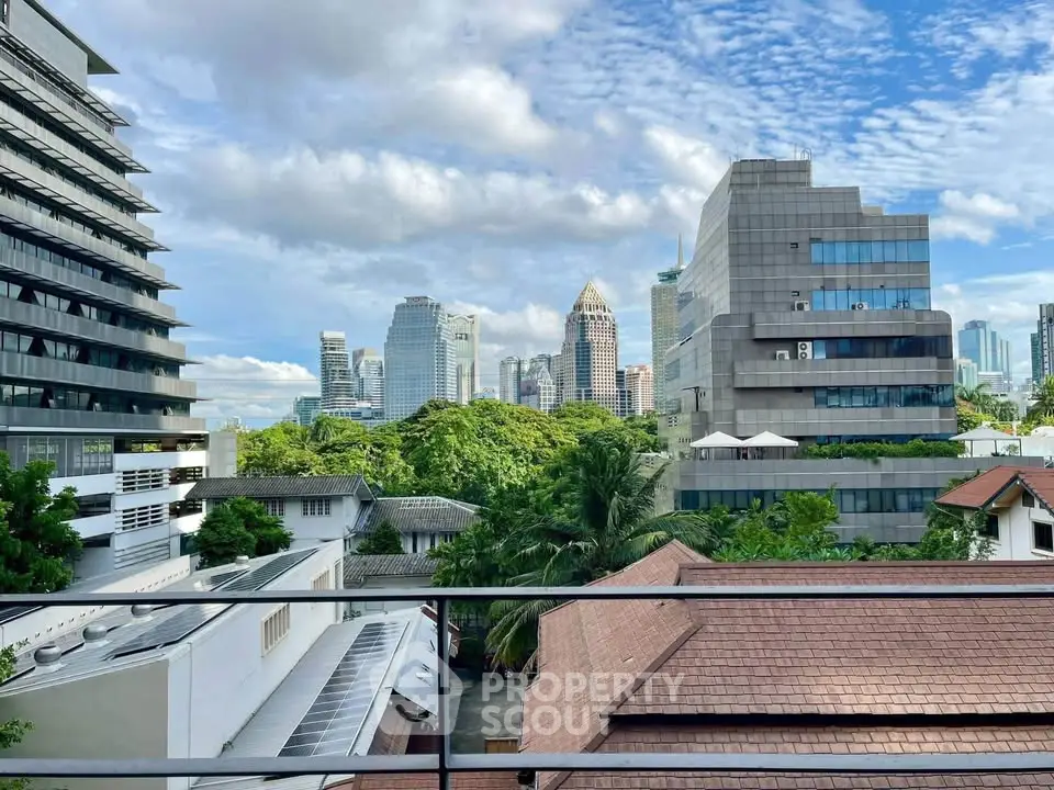 Stunning cityscape view from a modern balcony with lush greenery and skyline backdrop.
