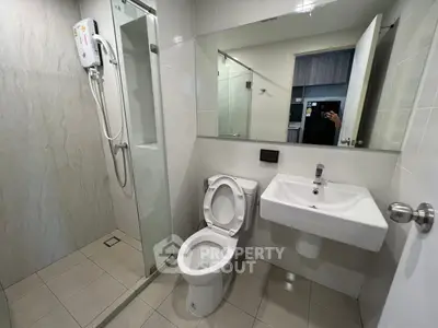 Modern bathroom with glass shower and sleek fixtures in a contemporary apartment.