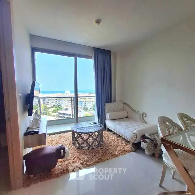 Chic living room with stunning ocean view, elegant furniture, and plush rug, perfect for relaxation.