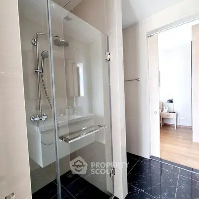 Modern bathroom with glass shower and sleek design in a contemporary home.