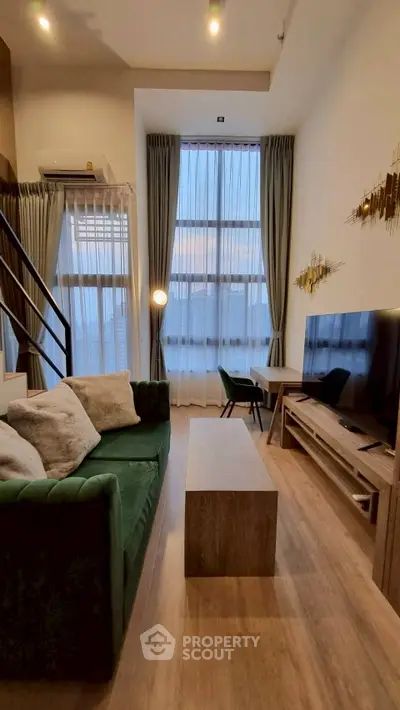 Modern living room with high ceilings, stylish decor, and large windows for natural light.