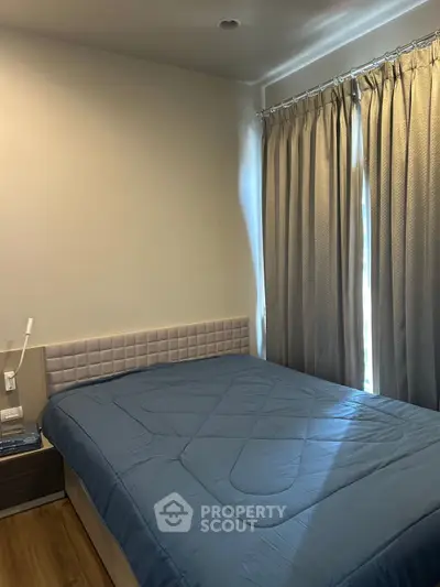 Cozy bedroom with modern design and natural light through large windows.