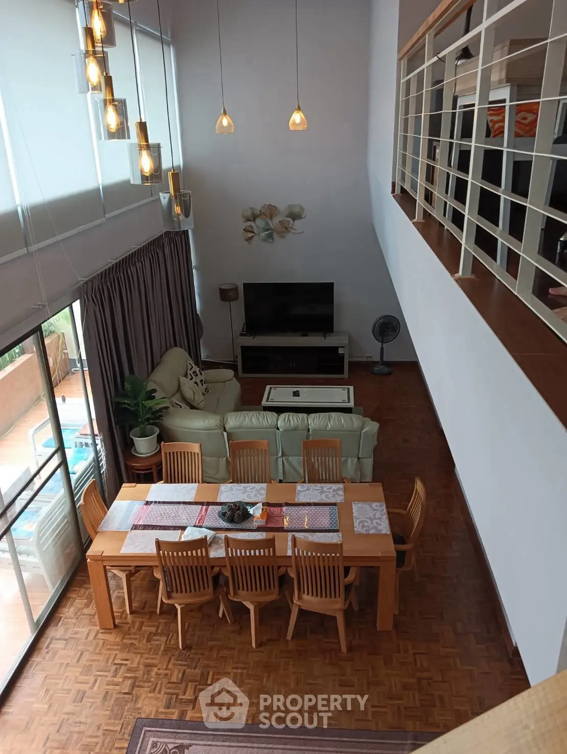 Spacious living room with high ceiling and elegant dining area, perfect for entertaining guests.
