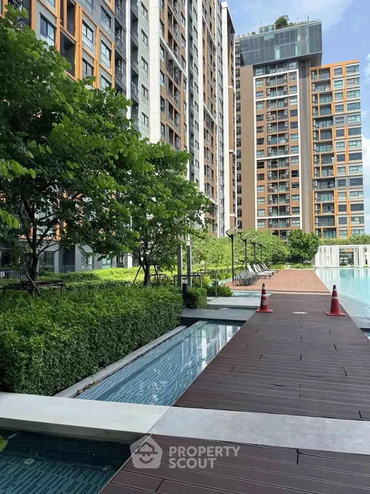 Modern apartment complex with pool and lush greenery, perfect for urban living.