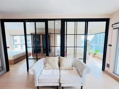 Spacious modern living room with elegant glass partitions and cozy seating, offering a bright and airy ambiance.