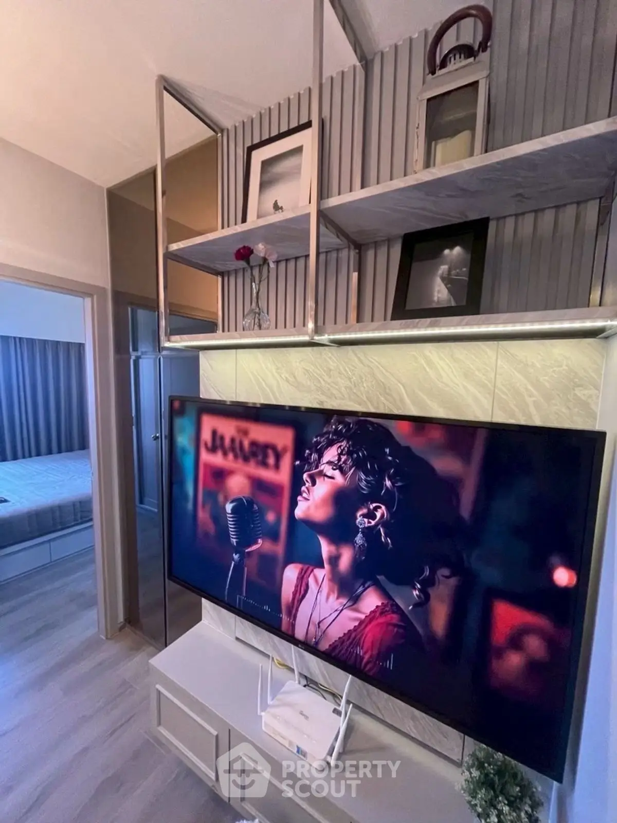 Modern living room with stylish shelving and large TV, showcasing contemporary interior design.