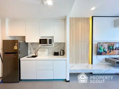 Modern kitchen with sleek white cabinets and integrated appliances in stylish apartment