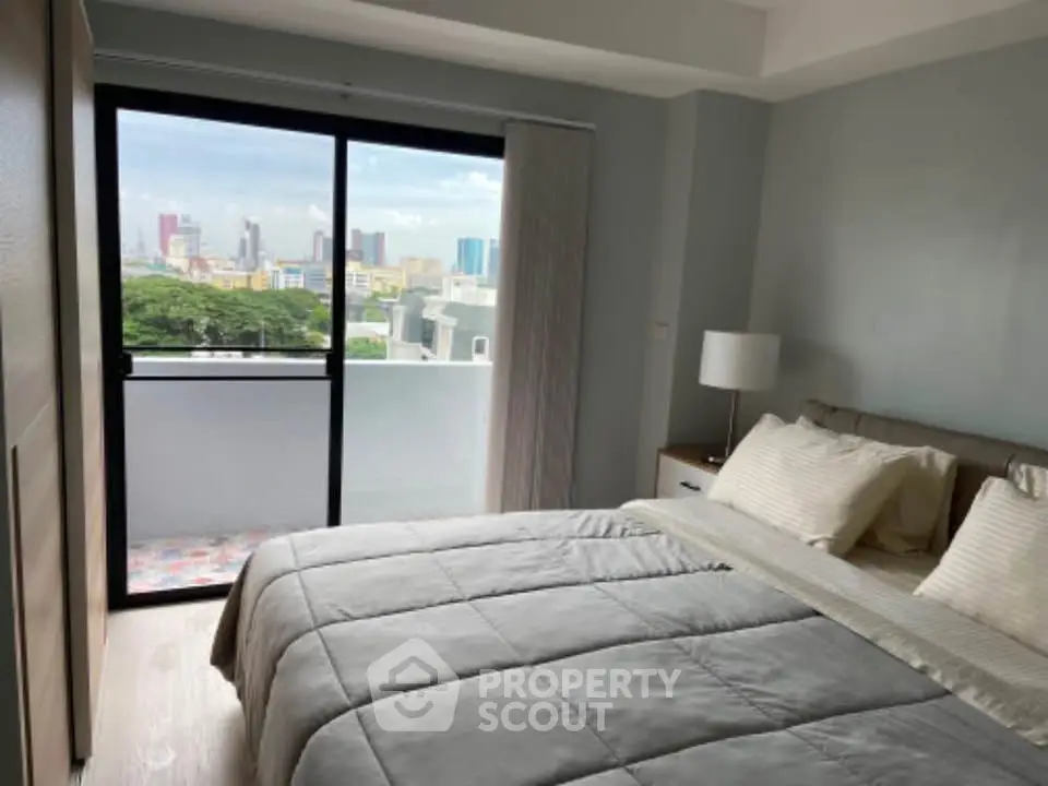Modern bedroom with balcony and city view in a high-rise apartment.
