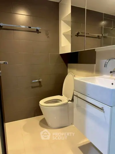 Modern bathroom with sleek fixtures and stylish brown tile walls.
