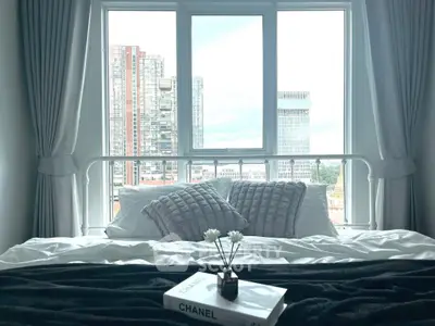 Modern bedroom with city view, stylish decor, and large windows for natural light.
