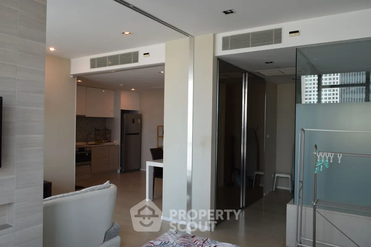 Modern open-plan living space with sleek kitchen and stylish decor in a high-rise apartment.