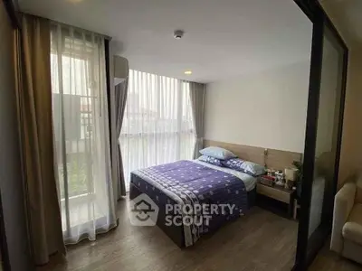 Modern bedroom with large windows and stylish decor in a cozy apartment.
