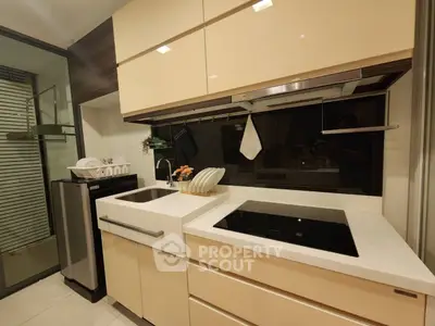 Modern kitchen with sleek cabinetry and induction cooktop in stylish apartment.