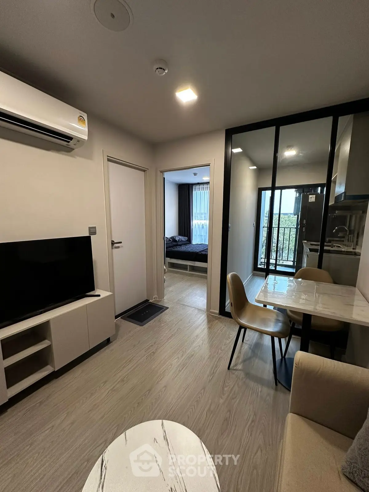 Modern apartment interior with open layout, featuring a cozy living area and dining space.