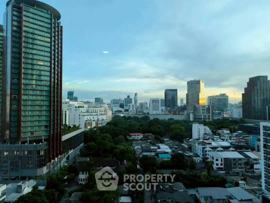 Stunning cityscape view from high-rise building with lush greenery and skyline.