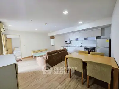 Spacious open-plan living room with modern kitchen and dining area, perfect for family gatherings.