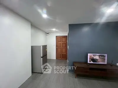Modern minimalist living space with sleek fridge and TV unit, perfect for urban living.
