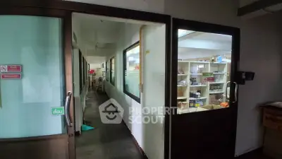 Commercial space with storage shelves and corridor view, ideal for retail or office use.
