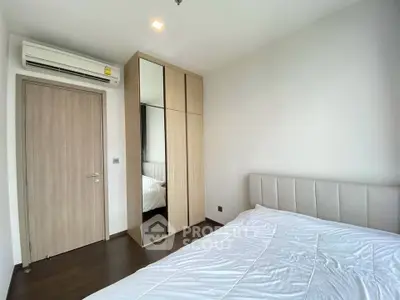 Modern bedroom with mirrored wardrobe and air conditioning unit