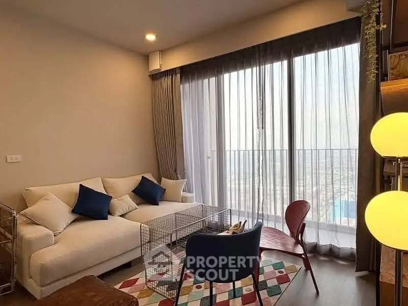 Modern living room with large windows and stylish furniture offering a stunning city view.