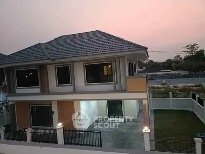 Charming two-story house with spacious yard and modern design at sunset, perfect for family living.