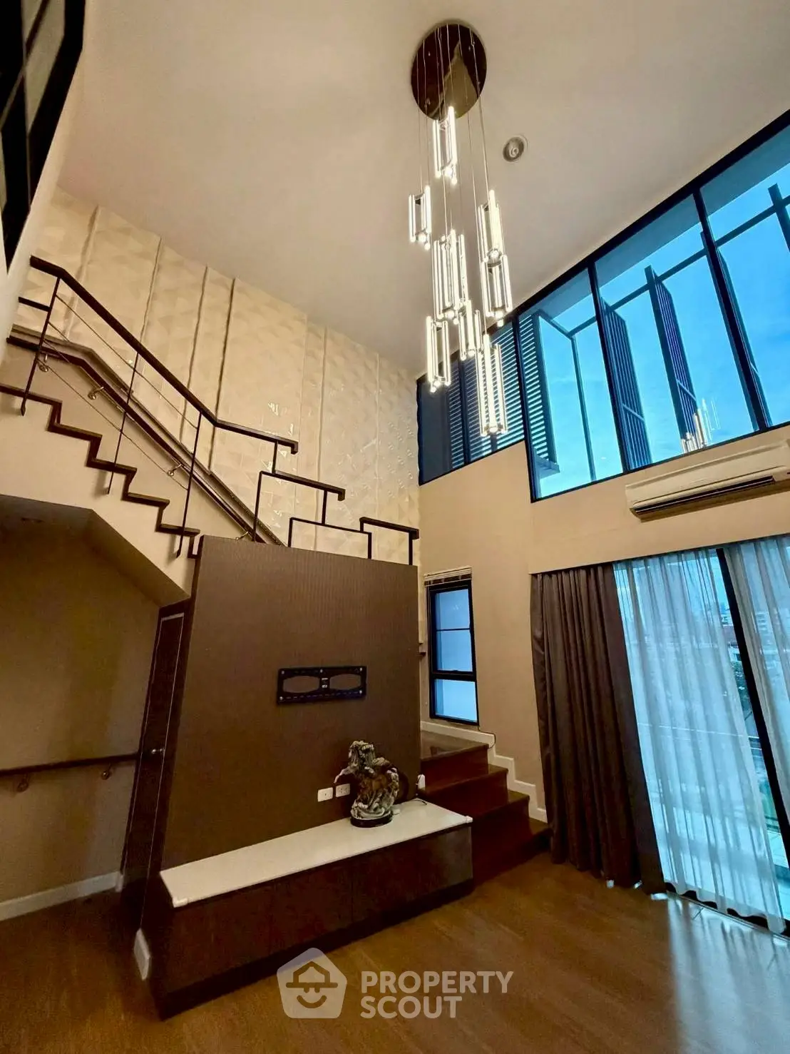 Stunning modern living room with high ceilings and elegant staircase in luxury apartment