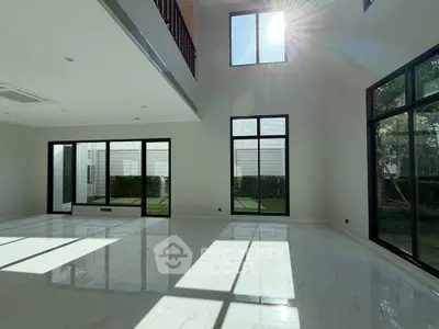 Spacious modern living room with high ceilings and large windows offering abundant natural light.