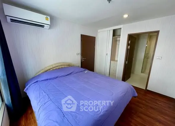 Spacious bedroom with modern design and ensuite bathroom in a stylish apartment.