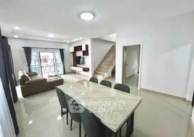 Spacious modern living and dining area with elegant marble table and cozy seating.