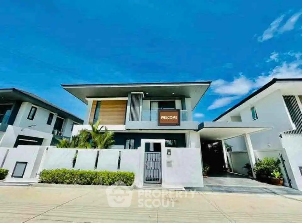 Modern two-story house with sleek design and welcoming entrance in a sunny neighborhood.